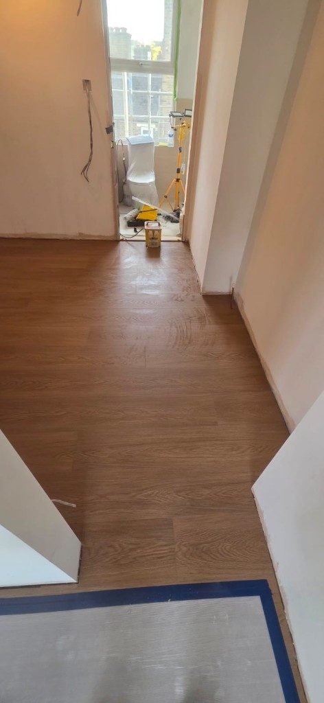 Wood plank flooring through hallway into adjoining room during renovation by Ikveles Construction