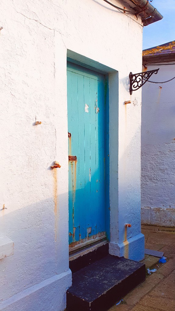 Weathered peeling blue wooden door before installation