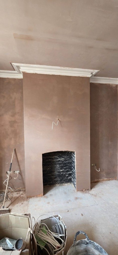 Freshly plastered chimney breast and fireplace opening by Ikveles Construction