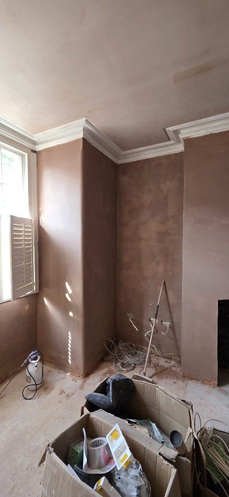 Fresh plaster on room walls and chimney breast with decorative coving by Ikveles Construction